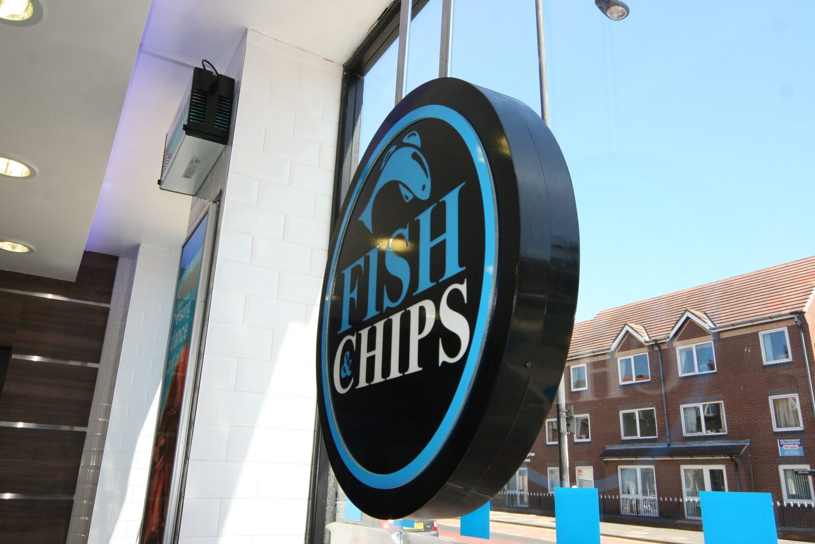 Circular illuminated projecting sign for a fish and chip shop
